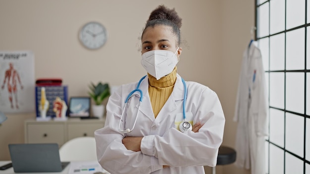 병원에서 의료용 마스크를 쓰고 서 있는 젊은 아프리카계 미국인 여성 의사