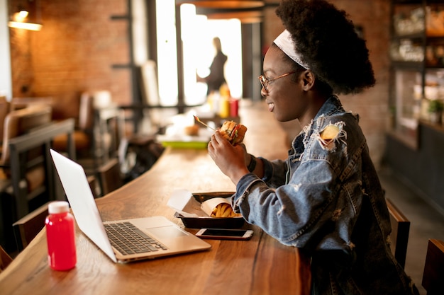 Young african american woman eating a burger