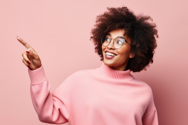 Foto giovane donna afroamericana con gli occhiali che indica su uno sfondo rosa capelli ricci