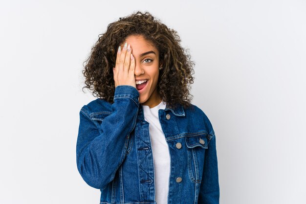 Young african american woman having fun covering half of face with palm.