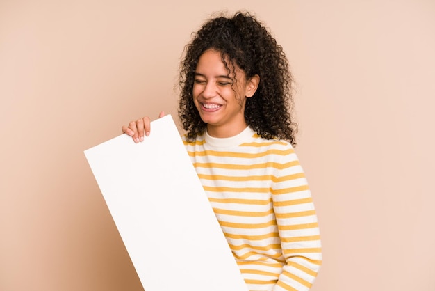 Young african american woman holding a banner isolated