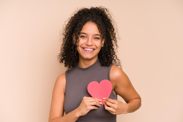 Young african american woman holding a paper heart, valentines day concept