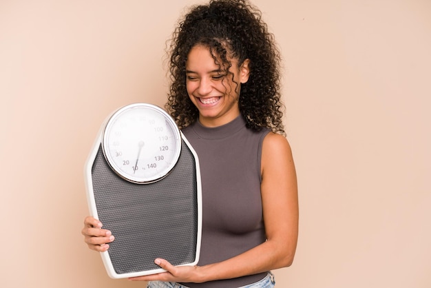 Young african american woman holding a scale isolated