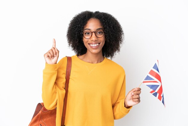 Young African American woman holding an United Kingdom flag isolated on white background showing and lifting a finger in sign of the best