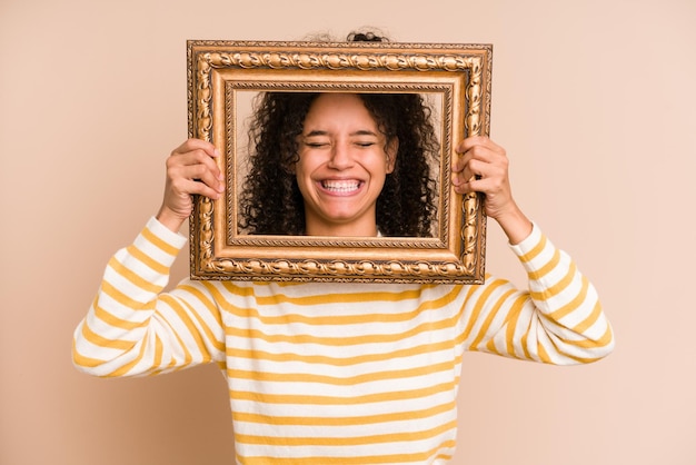 Photo young african american woman holding a vintage frame isolated