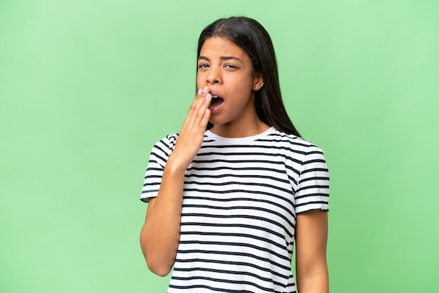 Молодая африканская американка на изолированном фоне зевает и прикрывает широко открытый рот рукой