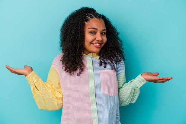 Young african american woman isolated on blue background showing a welcome expression.