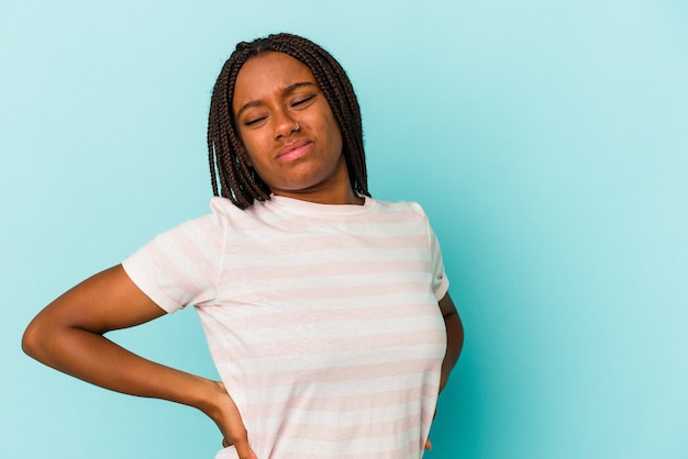 Young african american woman isolated on blue background  suffering a back pain.