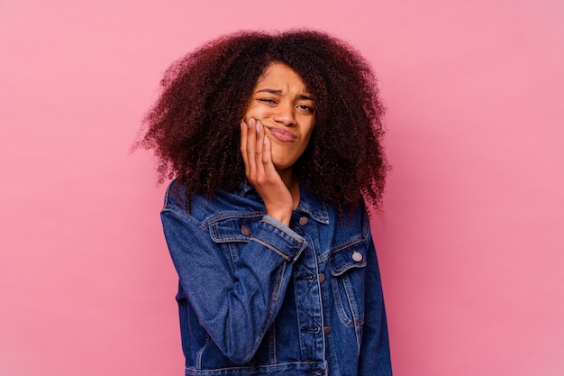 Young african american woman isolated on pink background having a strong teeth pain, molar ache.