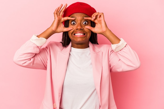 Young african american woman isolated on pink background  keeping eyes opened to find a success opportunity.