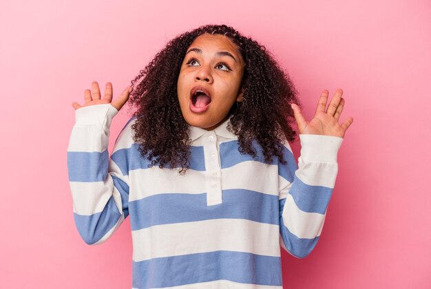 Photo young african american woman isolated on pink background screaming to the sky, looking up, frustrated.