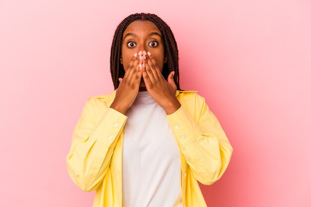 Young african american woman isolated on pink background  shocked covering mouth with hands.
