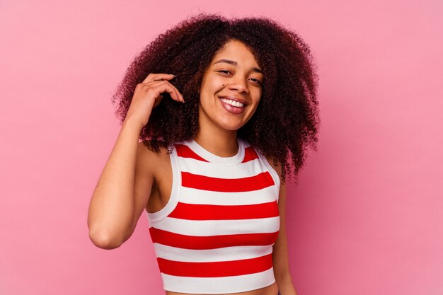 Young african american woman isolated on pink laughing about something, covering mouth with hands.