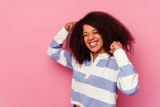 Young african american woman isolated on pink raising fist after a victory, winner concept.