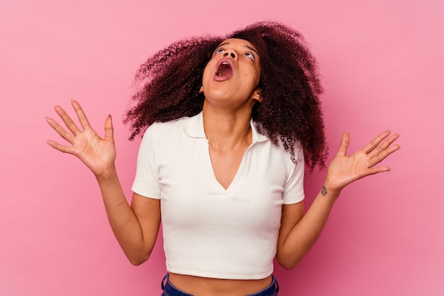 Young african american woman isolated on pink screaming to the sky, looking up, frustrated.