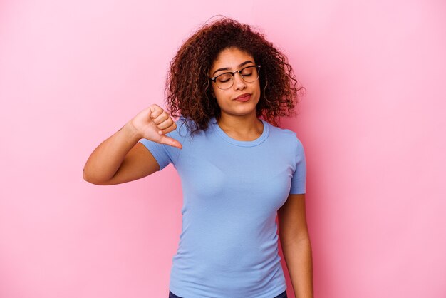 Foto giovane donna afroamericana isolata sul colore rosa che mostra un gesto di avversione, i pollici giù. concetto di disaccordo.