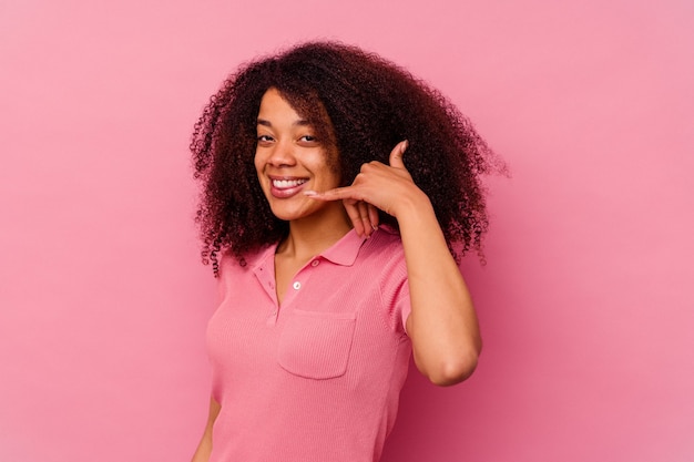 Young african american woman isolated on pink showing a mobile phone call gesture with fingers.