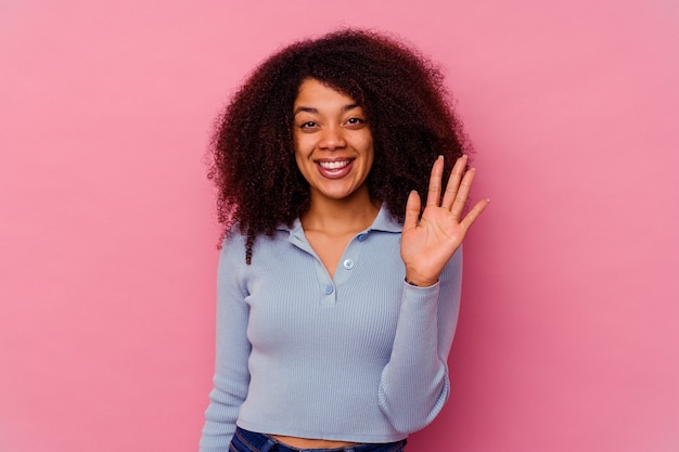 Young african american woman isolated on pink smiling cheerful showing number five with fingers.