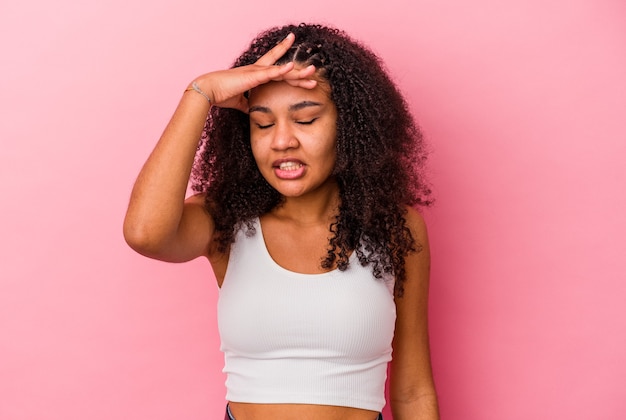 Young african american woman isolated on pink wall touching temples and having headache.