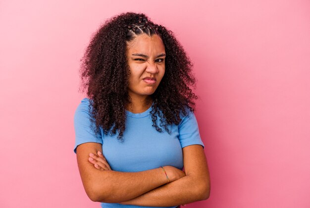 Young african american woman isolated on pink wall unhappy looking in front with sarcastic expression