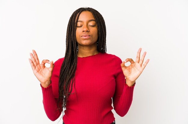 Young african american woman isolated relaxes after hard working day, she is performing yoga.