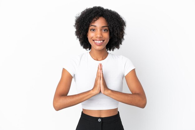 Young African American woman isolated on white background keeps palm together. Person asks for something