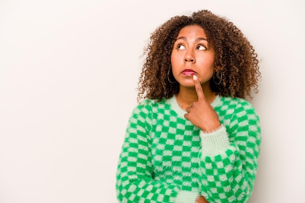 Young African American woman isolated on white background looking sideways with doubtful and skeptical expression