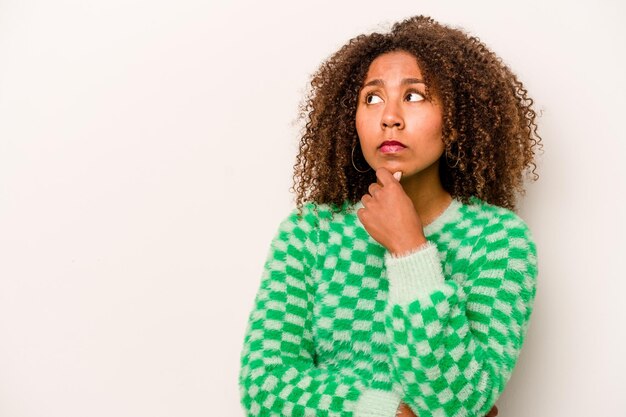 Young African American woman isolated on white background looking sideways with doubtful and skeptical expression