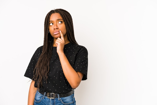 Young african american woman isolated on white background looking sideways with doubtful and skeptical expression.