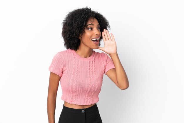 Young African American woman isolated on white background shouting with mouth wide open to the side