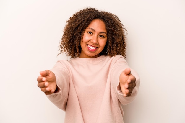 Foto giovane donna afroamericana isolata su sfondo bianco che mostra un'espressione di benvenuto