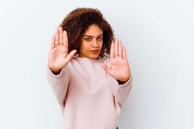 Foto giovane donna afroamericana isolata su sfondo bianco in piedi con la mano tesa che mostra il segnale di stop, impedendoti.