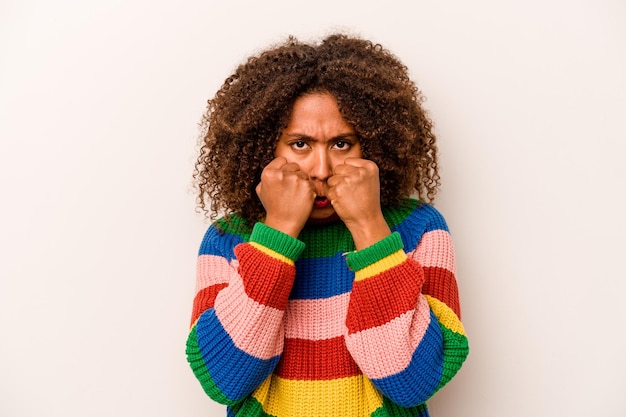 Young African American woman isolated on white background throwing a punch anger fighting due to an argument boxing