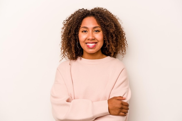 Young African American woman isolated on white background who feels confident crossing arms with determination