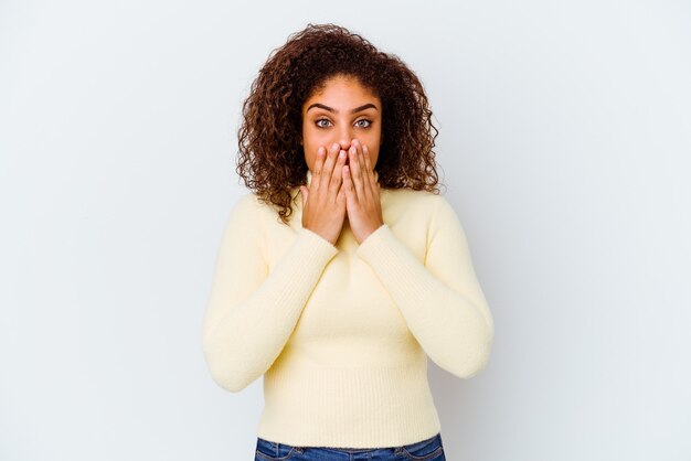 Young african american woman isolated on white shocked, covering mouth with hands, anxious to discover something new.