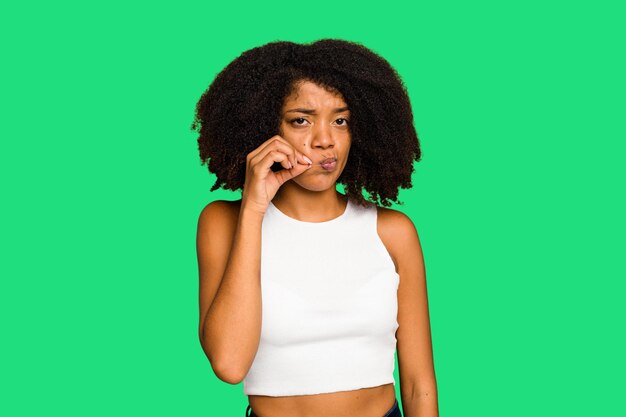 Photo young african american woman isolated with fingers on lips keeping a secret