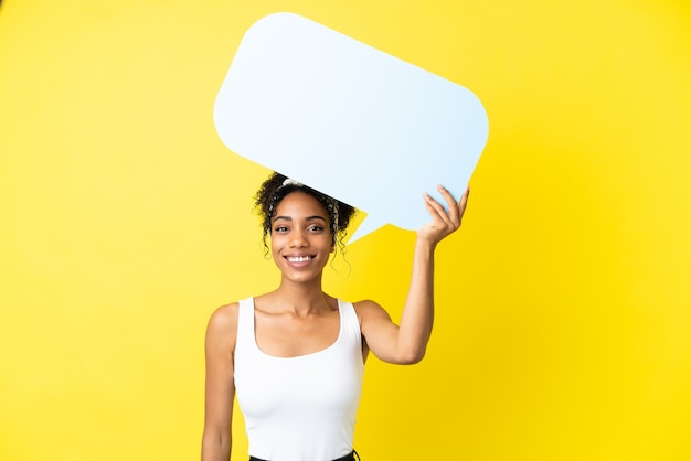 Young african american woman isolated on yellow background holding an empty speech bubble