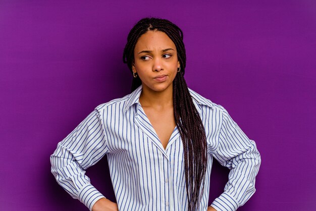 Young african american woman isolated on yellow confused, feels doubtful and unsure