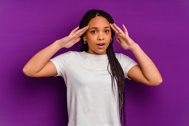 Young african american woman isolated on yellow receiving a pleasant surprise, excited and raising hands.