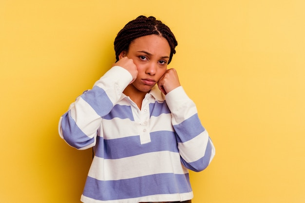 Young african american woman isolated on yellow wall whining and crying disconsolately.