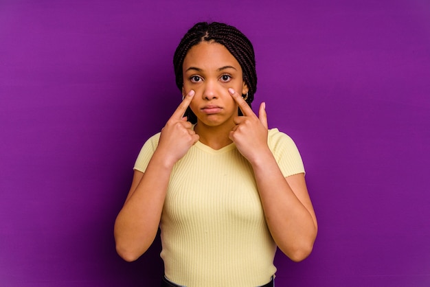 Young african american woman isolated on yellow wall Young african american woman isolated on yellow wall crying, unhappy with something, agony and confusion concept.