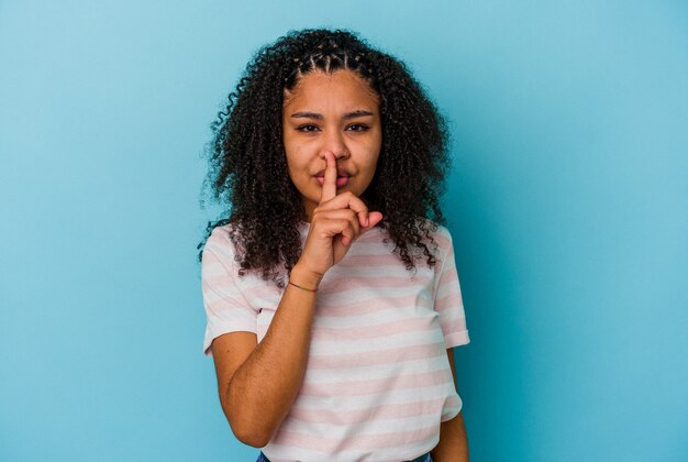 Young african american woman  keeping a secret or asking for silence.