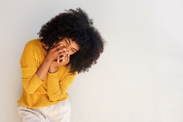 Young african american woman laughing against white background