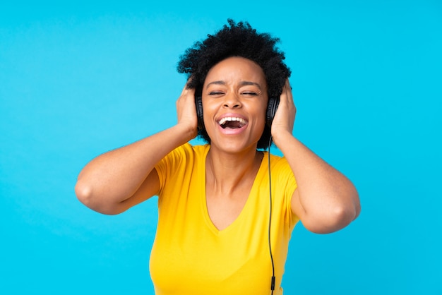 Young african american woman listening music with a mobile