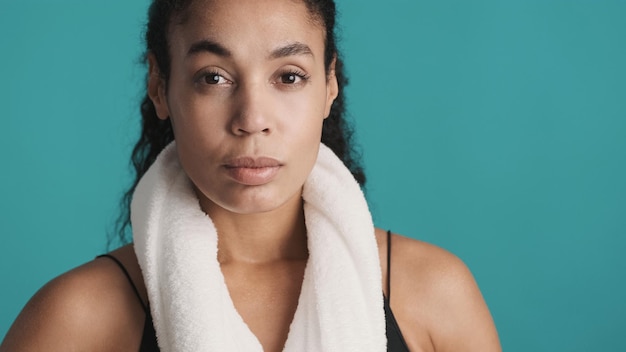 Foto giovane donna afroamericana che sembra sicura sulla fotocamera dopo un duro allenamento su sfondo blu concetto di sport