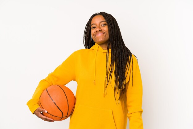 Young african american woman playing basketball isolated dreaming of achieving goals and purposes