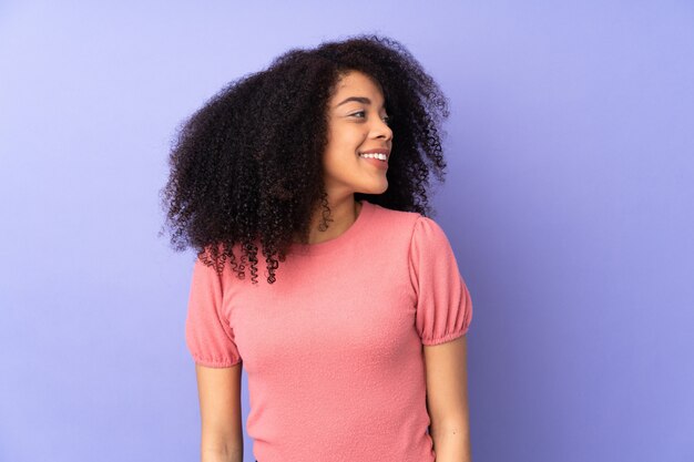側にいると笑顔の紫色の壁に若いアフリカ系アメリカ人女性