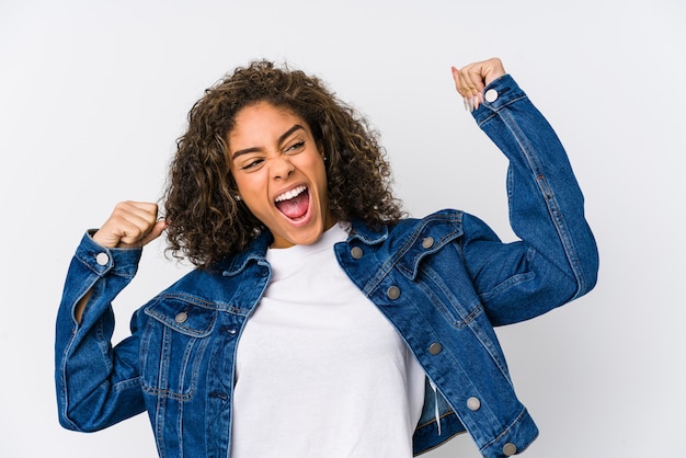 Young african american woman raising fist after a victory, winner concept.