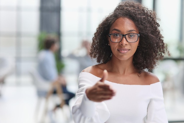 Young african american woman shaking hands in modern office