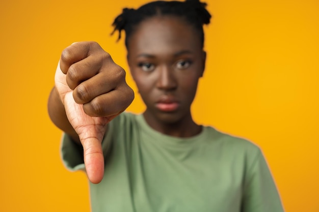 Photo young african american woman showing a dislike gesture